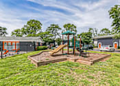 Thumbnail 22 of 25 - A playground with a slide and a green canopy structure.