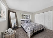 Thumbnail 6 of 32 - Bedroom at Renaissance at Carol Stream featuring a large bed and wall mirror in Carol Stream, IL.