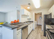 Thumbnail 1 of 20 - A kitchen with black appliances and white cabinets.