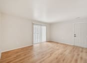 Thumbnail 5 of 31 - A room with wooden flooring and a white door.