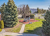 Thumbnail 18 of 20 - A park with a playground and trees.