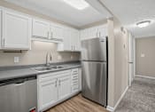 Thumbnail 1 of 27 - Apartment kitchen with a stainless steel refrigerator and white cabinets at Arbours at Victoria Place in Prattville, AL