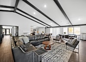 Thumbnail 15 of 34 - A modern living room with a black leather couch and a wooden coffee table.