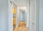 Thumbnail 9 of 21 - A long hallway with a door on the right.
