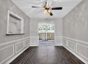 Thumbnail 4 of 30 - A room with a ceiling fan and a window with a view of trees.