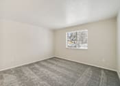 Thumbnail 12 of 31 - A room with a carpeted floor and a picture hanging on the wall.
