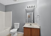Thumbnail 12 of 18 - A white toilet sits next to a white sink in a bathroom.