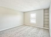 Thumbnail 11 of 21 - A room with a carpeted floor and a window.