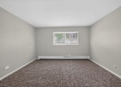 Thumbnail 16 of 32 - Open bedroom at Renaissance at Carol Stream featuring a window and carpeted floor in Carol Stream, IL.