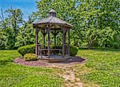Thumbnail 19 of 21 - A gazebo is surrounded by a grassy area and trees.