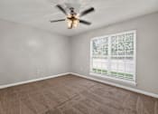 Thumbnail 8 of 30 - A room with a ceiling fan and a window with blinds.