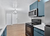 Thumbnail 3 of 24 - A kitchen with blue cabinets and a stove top oven.