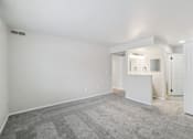 Thumbnail 11 of 31 - A large empty room with a carpeted floor and a mirrored wall.