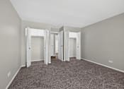 Thumbnail 17 of 32 - Bedroom at Renaissance at Carol Stream featuring carpeted floor, white walls, and a large closet in Carol Stream, IL.