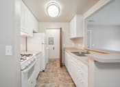 Thumbnail 38 of 39 - A kitchen with white appliances and cabinets.