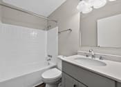 Thumbnail 18 of 32 - White bathroom at Renaissance at Carol Stream featuring a toilet, sink, and shower in Carol Stream, IL.