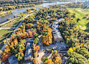 Thumbnail 1 of 34 - A beautiful aerial view of a golf course surrounded by trees in autumn.