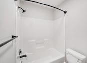 Thumbnail 8 of 31 - A white bathroom with a toilet, sink, and bathtub.