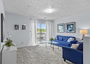 Thumbnail 7 of 39 - a living room with blue couches and a glass coffee table