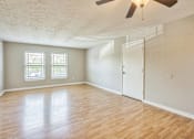 Thumbnail 15 of 21 - A room with a ceiling fan and wooden flooring.