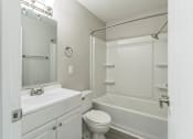 Thumbnail 5 of 30 - A white bathroom with a toilet, sink, and bathtub.