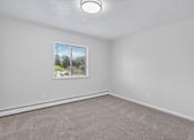 Thumbnail 5 of 24 - A room with a window and a carpeted floor.