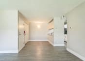 Thumbnail 3 of 30 - A room with a wooden floor and white walls.