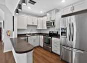 Thumbnail 22 of 32 - Community kitchen at Renaissance at Carol Stream featuring stainless steel appliances and white cabinets in Carol Stream, IL.