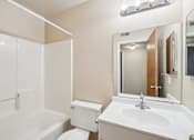 Thumbnail 18 of 31 - A white bathroom with a toilet, sink, and bathtub.