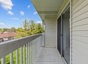 Thumbnail 14 of 39 - the view from the balcony of a home with white walls and a balcony door open