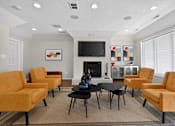Thumbnail 21 of 32 - Community clubhouse at Renaissance at Carol Stream featuring seating, a fireplace, and a TV in Carol Stream, IL.