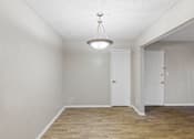 Thumbnail 10 of 22 - A room with a light hanging from the ceiling and two doors.
