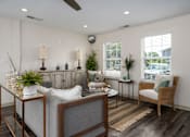 Thumbnail 1 of 23 - A living room with a grey couch, a wooden coffee table, and a ceiling fan.