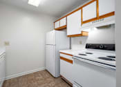 Thumbnail 18 of 23 - Kitchen with wood cabinets and appliances at Arbours at Victoria Place Prattville AL