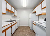Thumbnail 16 of 23 - A kitchen with white cabinets and brown trim.