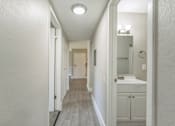 Thumbnail 4 of 30 - A long hallway with a bathroom at the end.