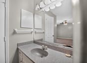 Thumbnail 11 of 30 - A bathroom with a sink, mirror, and light fixture.