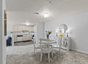 Thumbnail 6 of 39 - a dining area with a table and chairs and a kitchen in the background