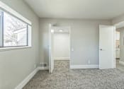 Thumbnail 8 of 30 - A room with a carpeted floor and a window.