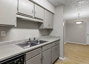 Thumbnail 8 of 22 - A kitchen with a sink, dishwasher, and cabinets.