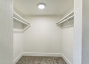 Thumbnail 14 of 30 - A small, empty room with a carpeted floor and a single light fixture on the ceiling.