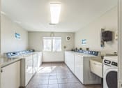 Thumbnail 26 of 30 - A laundry room with washers and dryers.