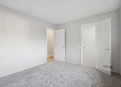 Thumbnail 11 of 26 - A room with a carpeted floor and three doors.
