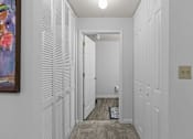 Thumbnail 10 of 39 - a hallway with white closet doors and a door to a bathroom