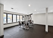 Thumbnail 22 of 34 - A gym with a rowing machine and a bench.