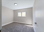 Thumbnail 15 of 30 - A room with a window and carpeted floor.