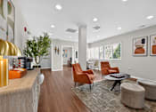 Thumbnail 23 of 32 - Community lounge at Renaissance at Carol Stream featuring orange chairs and a wooden floor in Carol Stream, IL.