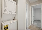 Thumbnail 12 of 26 - A white electric dryer is on the wall next to a door.