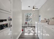 Thumbnail 26 of 30 - A white kitchen with a window and a ceiling fan.