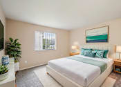 Thumbnail 15 of 31 - A bedroom with a large bed and a painting on the wall.